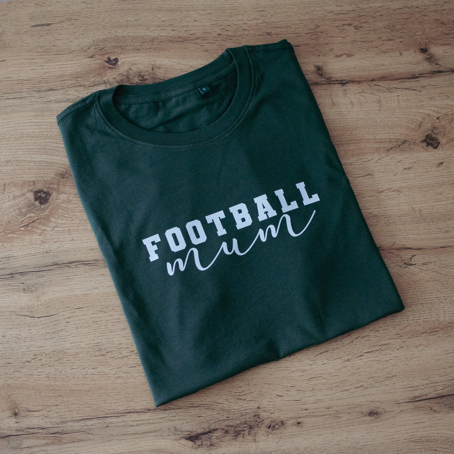 Forest Green T-Shirt with text "Football Mum" in white against wooden background