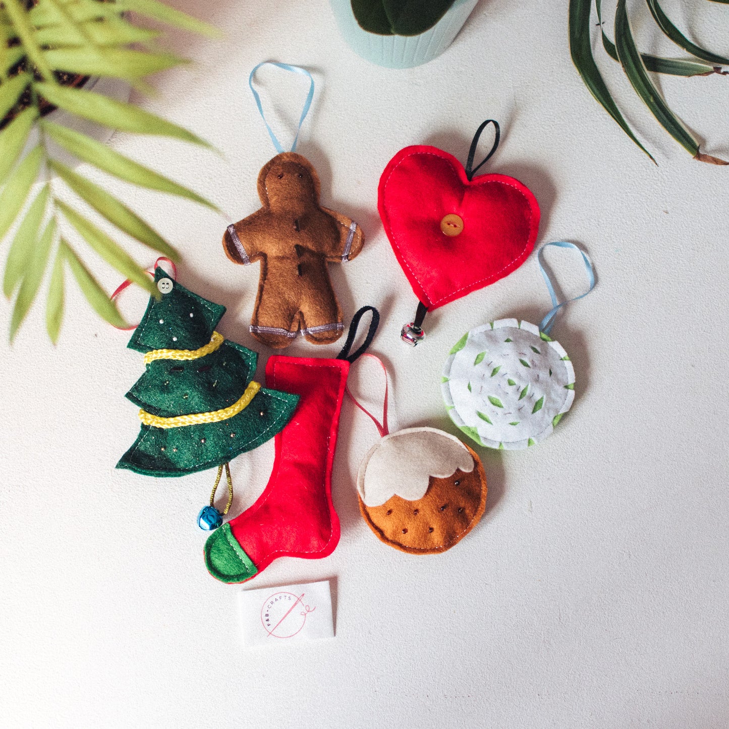 Handmade Christmas Felt Decorations Pack: A group of six or five charming felt Christmas ornaments, including gingerbread men, hearts, Christmas trees, stockings, snowmen, and baubles.