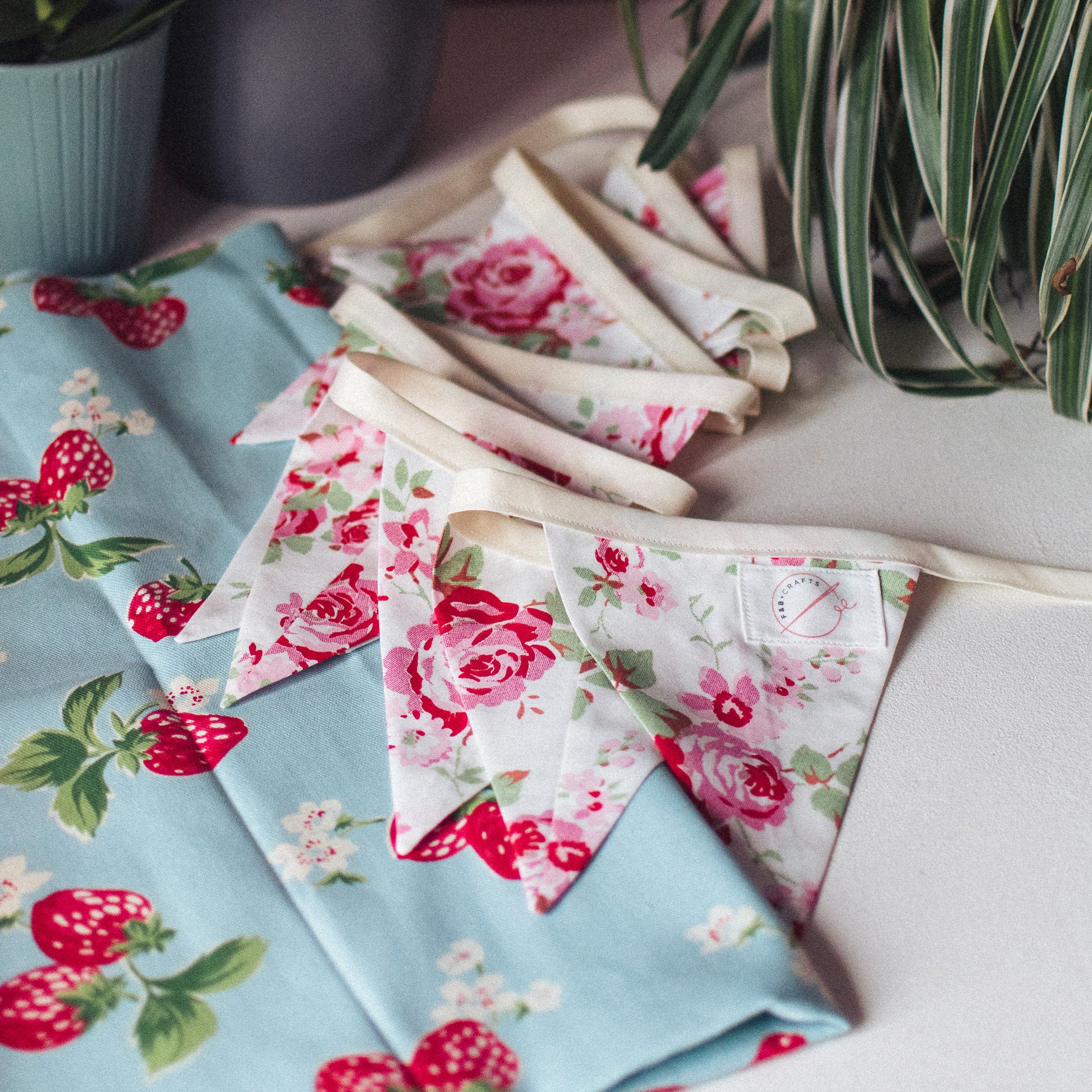 Rosali Vintage Style Cath Kidston Bunting draped against a charming strawberry print Cath Kidston fabric backdrop.