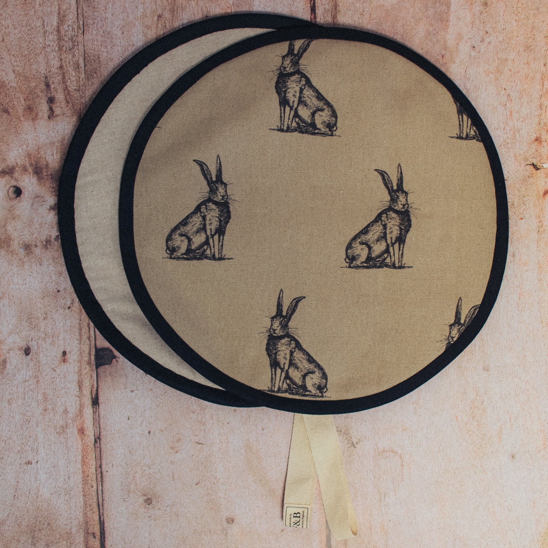 Hare Illustration Print on Linen fabric with Black binding photographed against light wood background